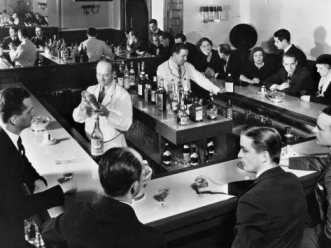 alt="Bartender prepares drinks for patrons at a popular Prohibition era speakeasy during "